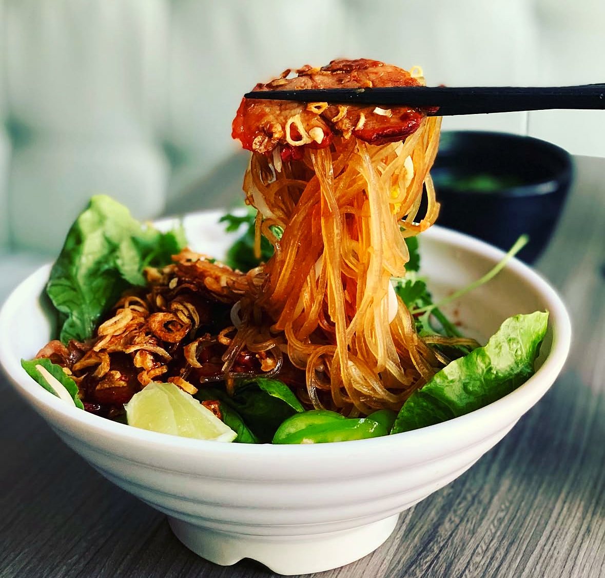 Dry phở noodles lifted with chopsticks